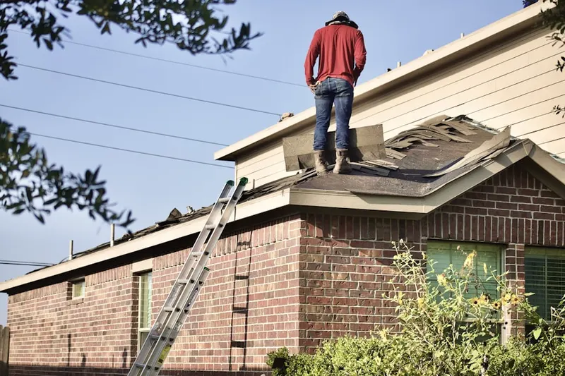Professional roofer working on a residential roof in Hoffman